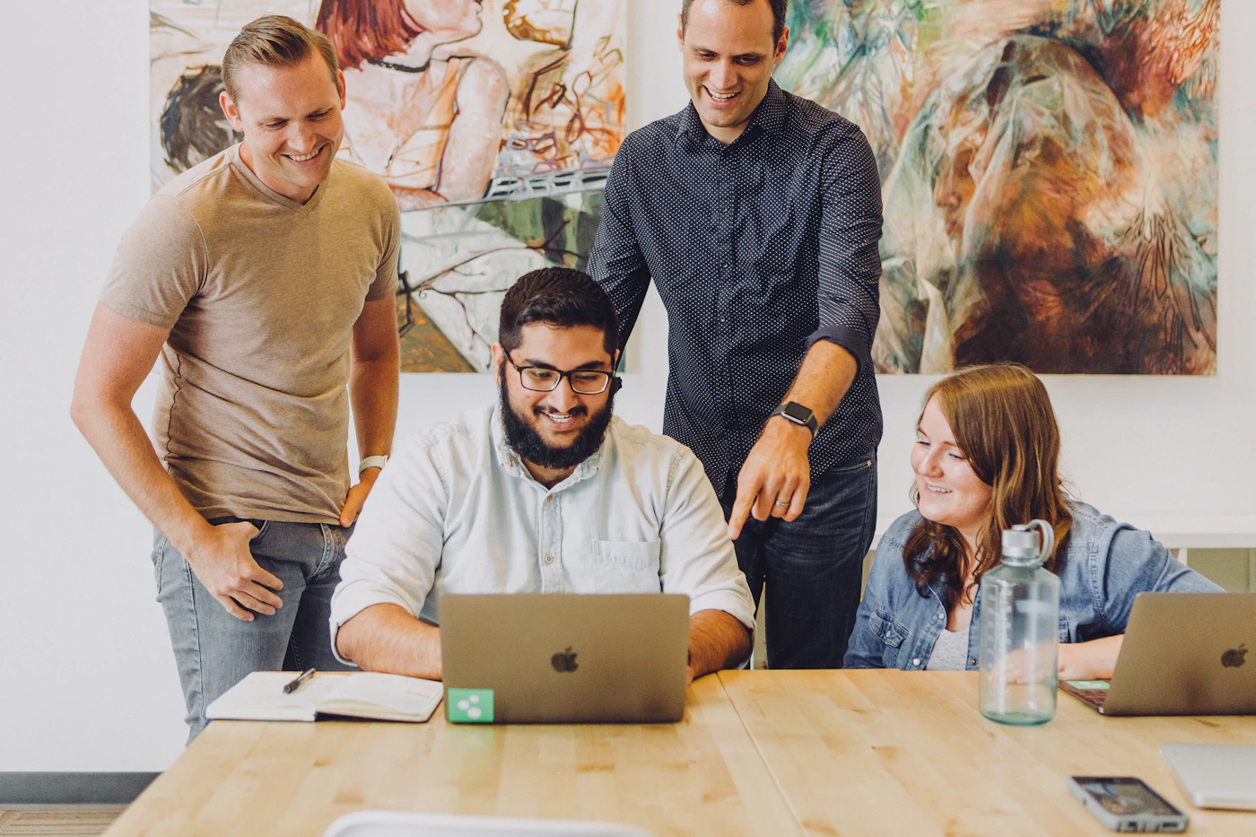 Creative team collaborating around a laptop